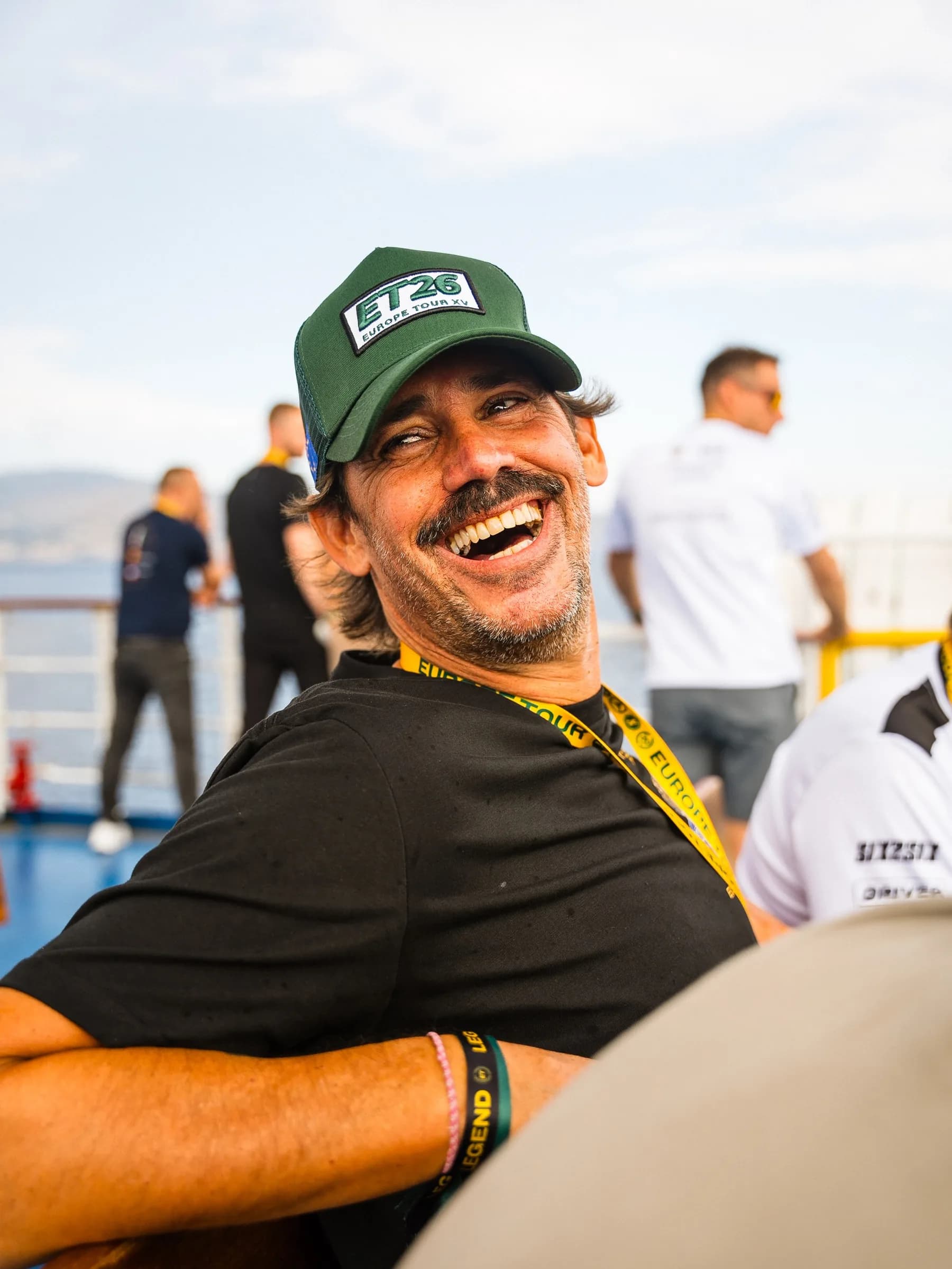 A SIX2SIX driver laughing on a ferry deck, wearing the ET26 trucker cap
